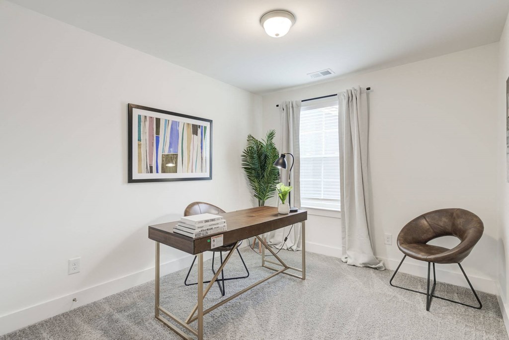 a home office with white walls and carpeting