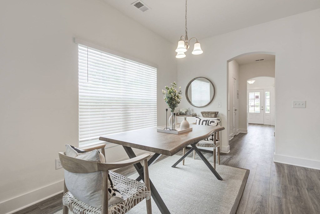a dining area with white walls and hardwood floors