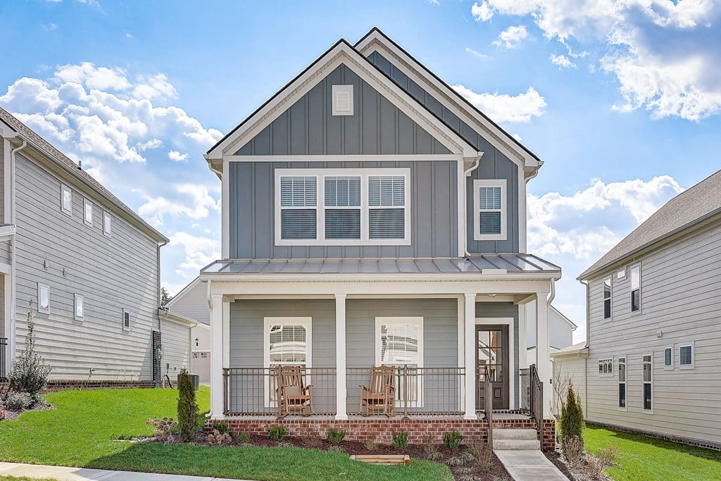 the front of a house with chairs on the porch