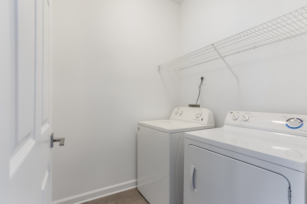 A white laundry room with a washer and dryer.