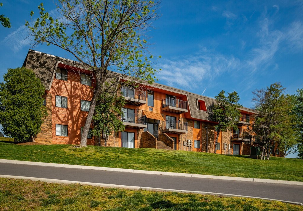 A large multi-story building with a red brick exterior and balconies.