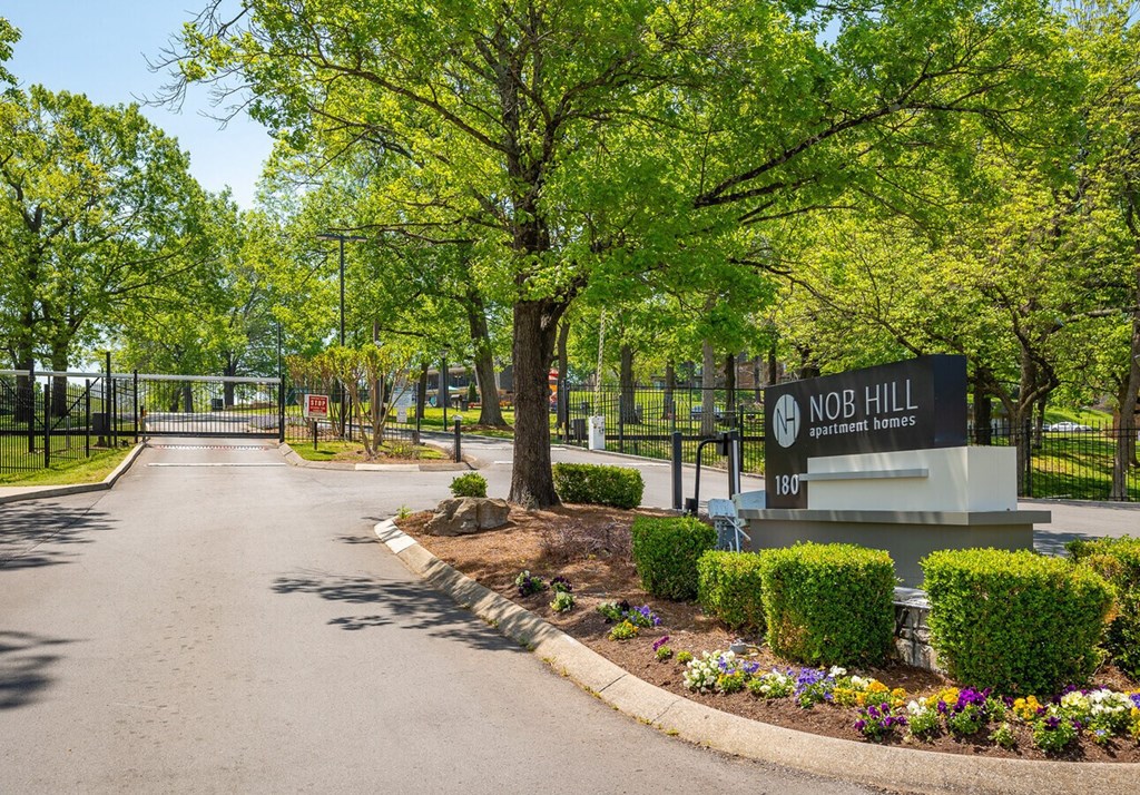 The image shows a sign for NOB HILL apartments with a road leading to it.
