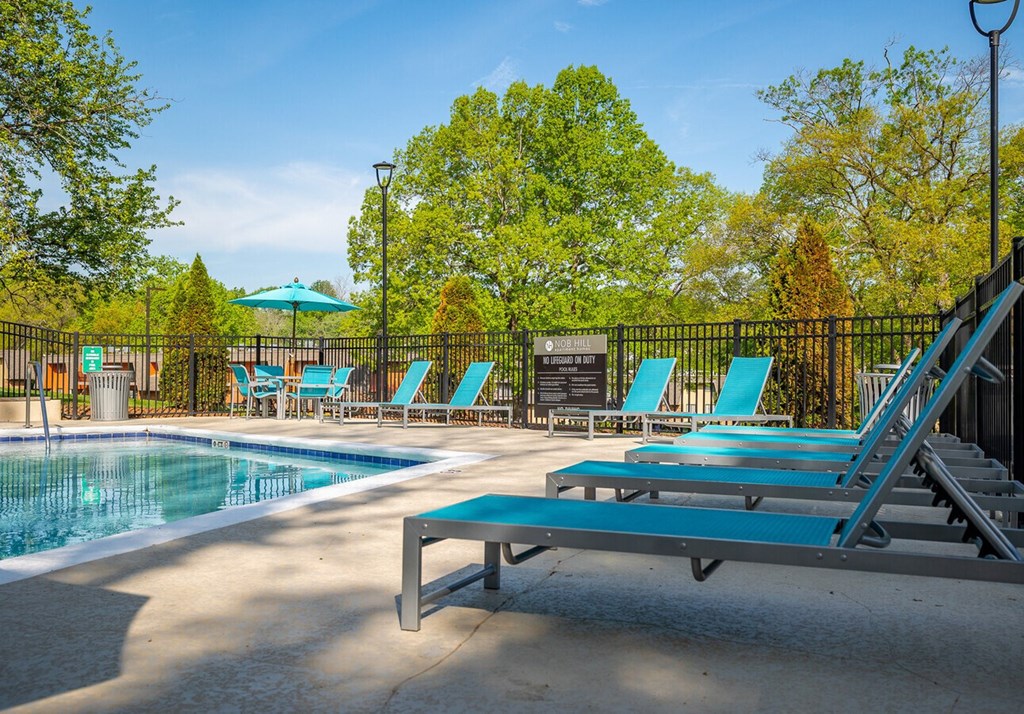 A pool area with a slide and sun loungers.