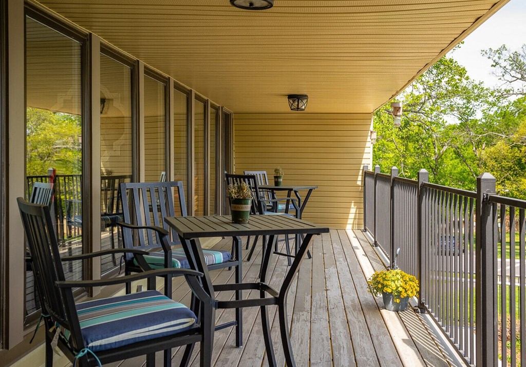 A wooden deck with a table and chairs.