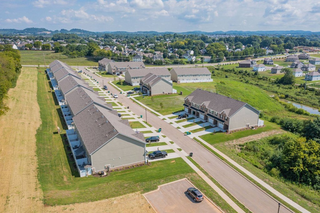 an aerial view of a group of houses with cars parked in front of them