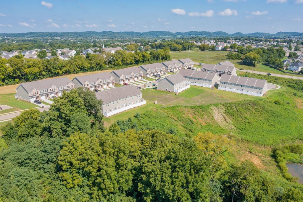 a group of buildings on a grassy hill