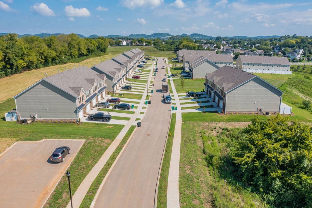 a row of houses with cars parked in front of them