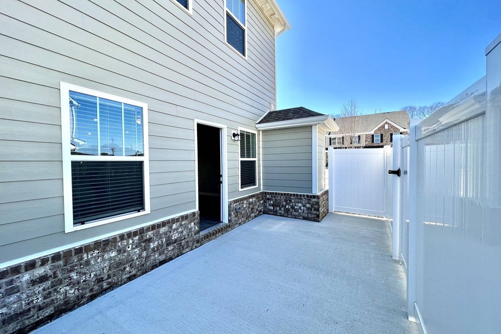 a garage with a white fence and a house in the background