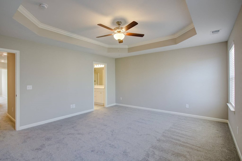 an empty bedroom with a ceiling fan
