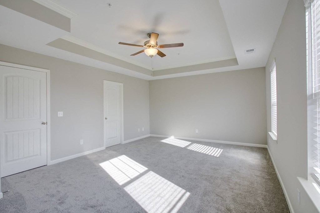 an empty bedroom with a ceiling fan