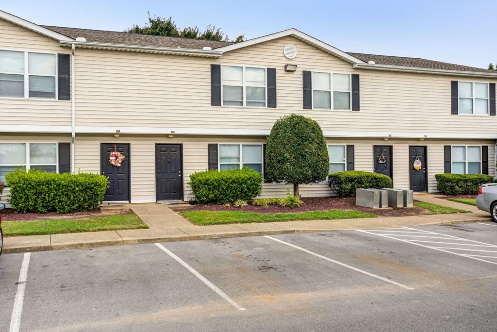 a white house with a parking lot in front of it