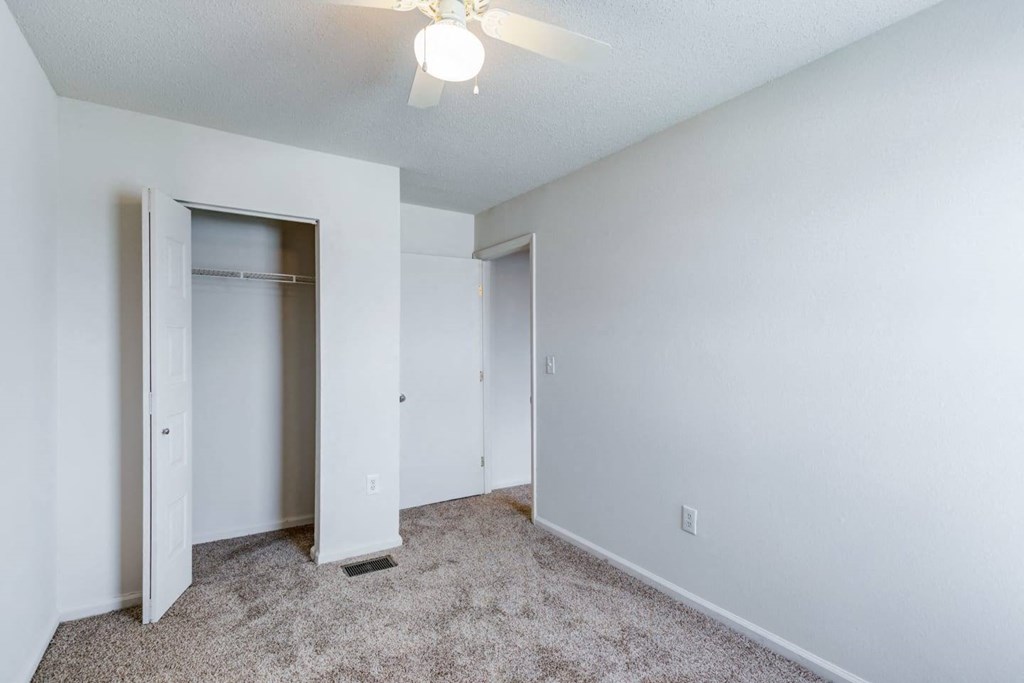 a bedroom with a closet and a ceiling fan