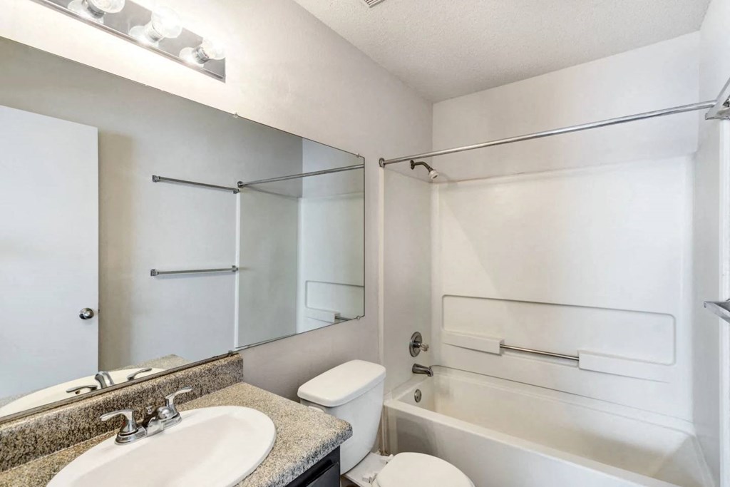 a bathroom with a sink toilet and shower and a mirror