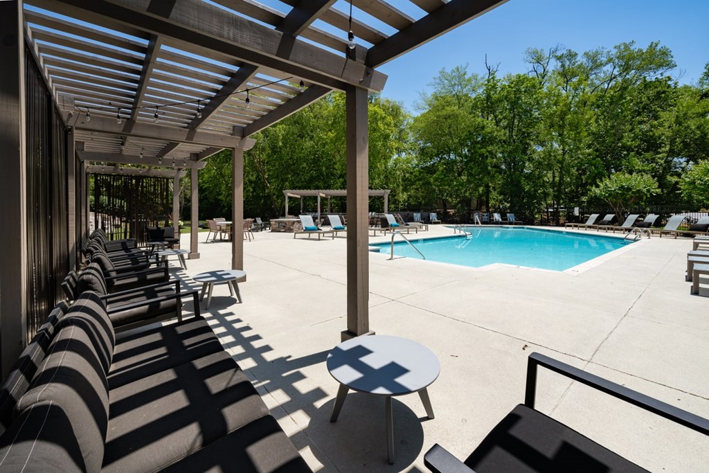 A pool area with sun loungers and a table.