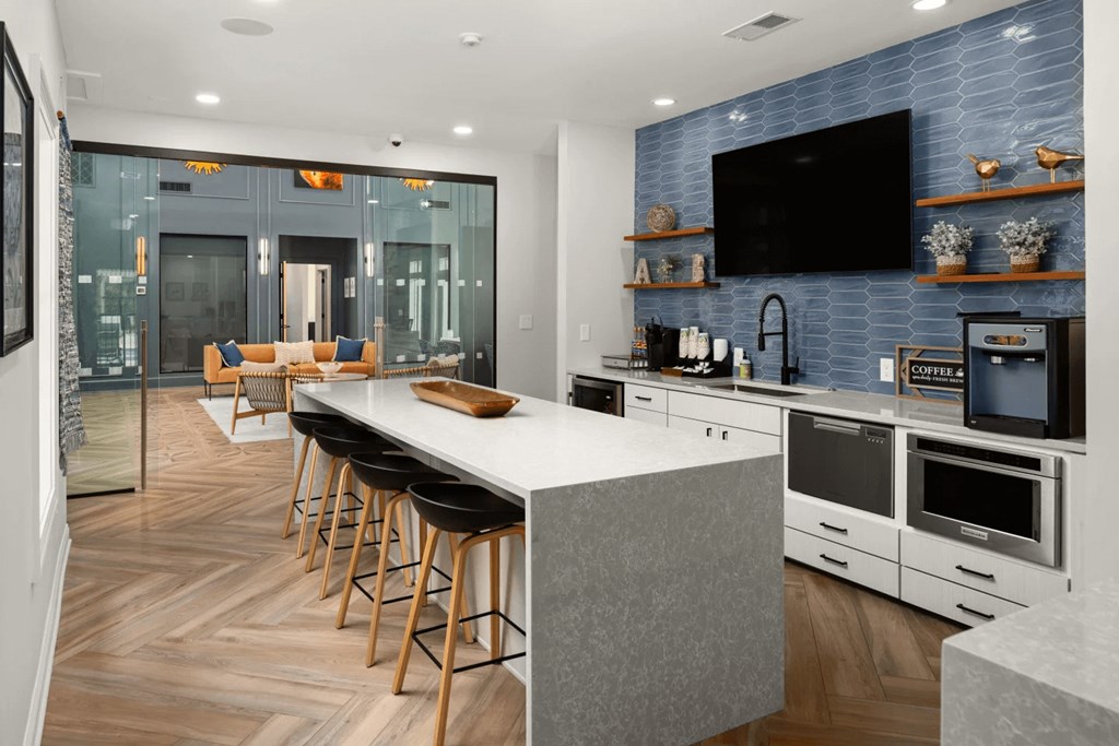 A modern kitchen with a bar area and a television mounted on the wall.