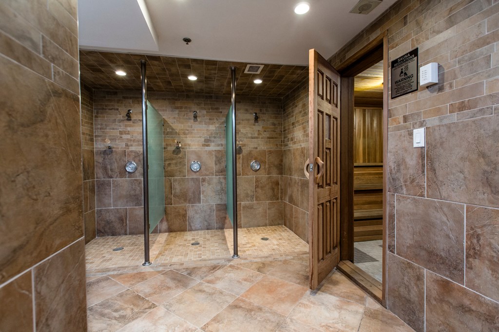 A bathroom with a walk in shower and a wooden door.