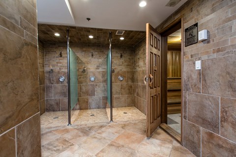 A bathroom with a walk in shower and a wooden door.