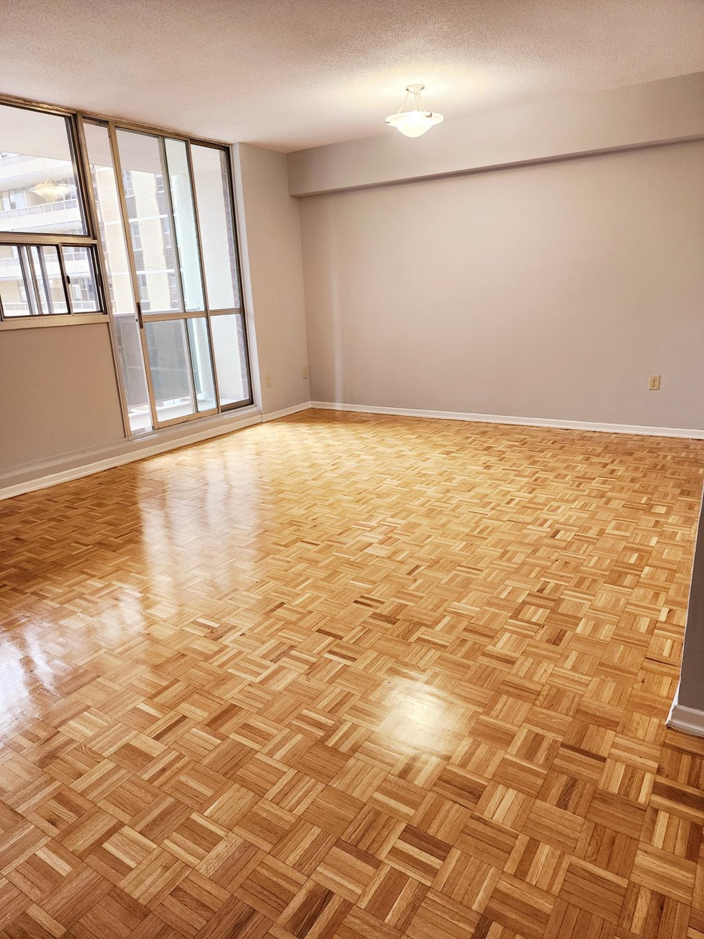 A room with wooden flooring and a window.