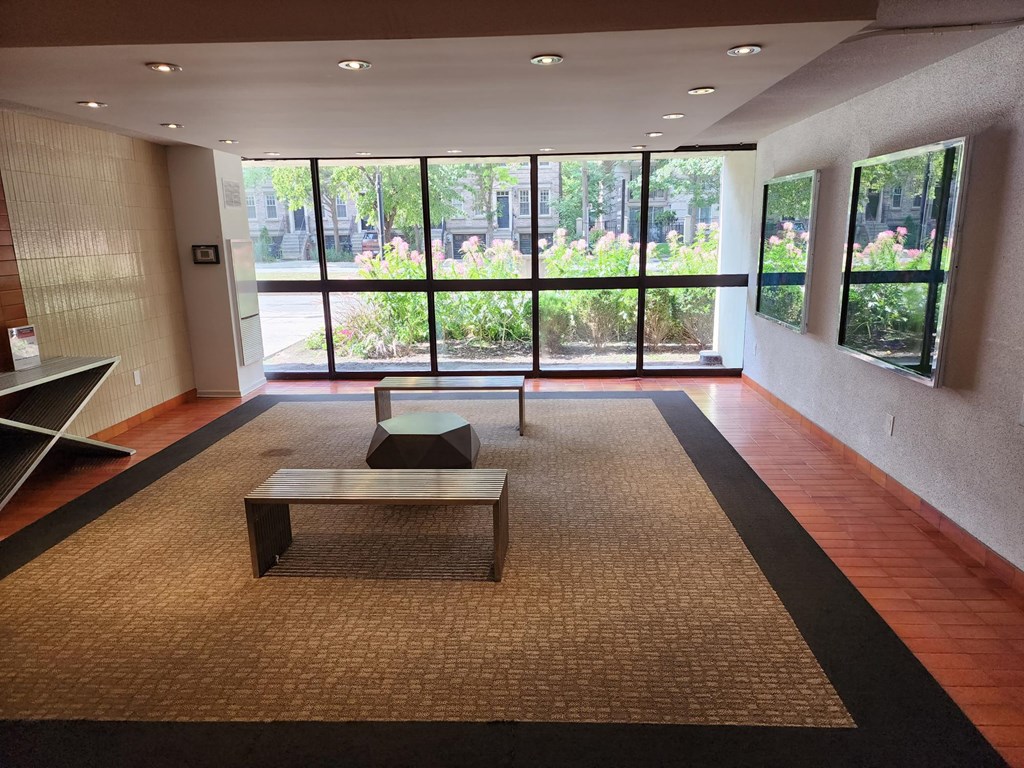 A room with a bench and a table in front of a window.