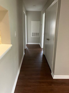 A long hallway with LVP floors and Agreeable Grey Walls