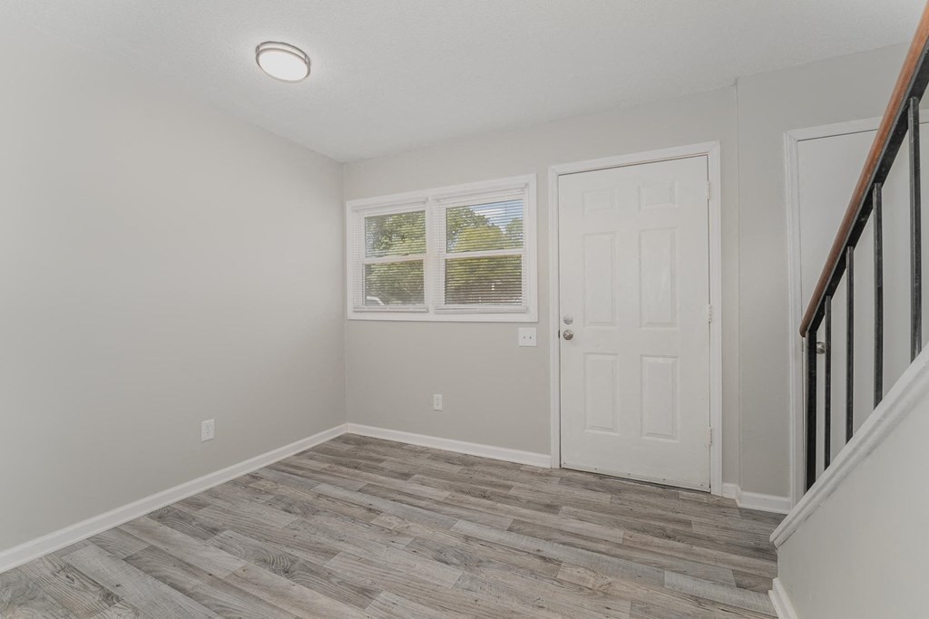 a bedroom with hardwood floors and grey walls
