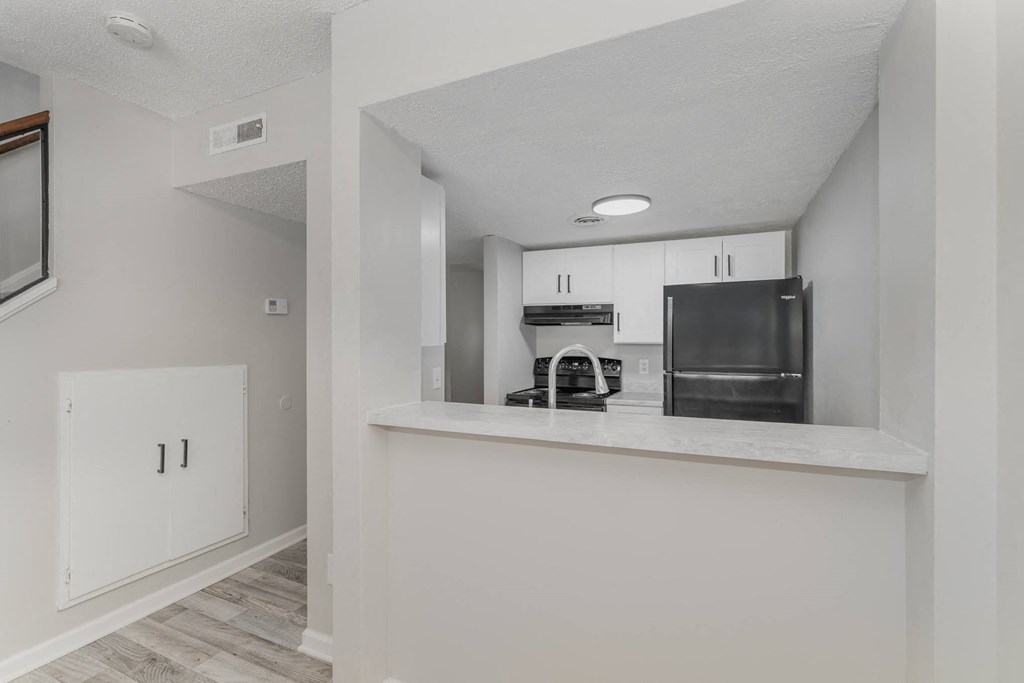 a kitchen with white cabinets and a stainless steel refrigerator