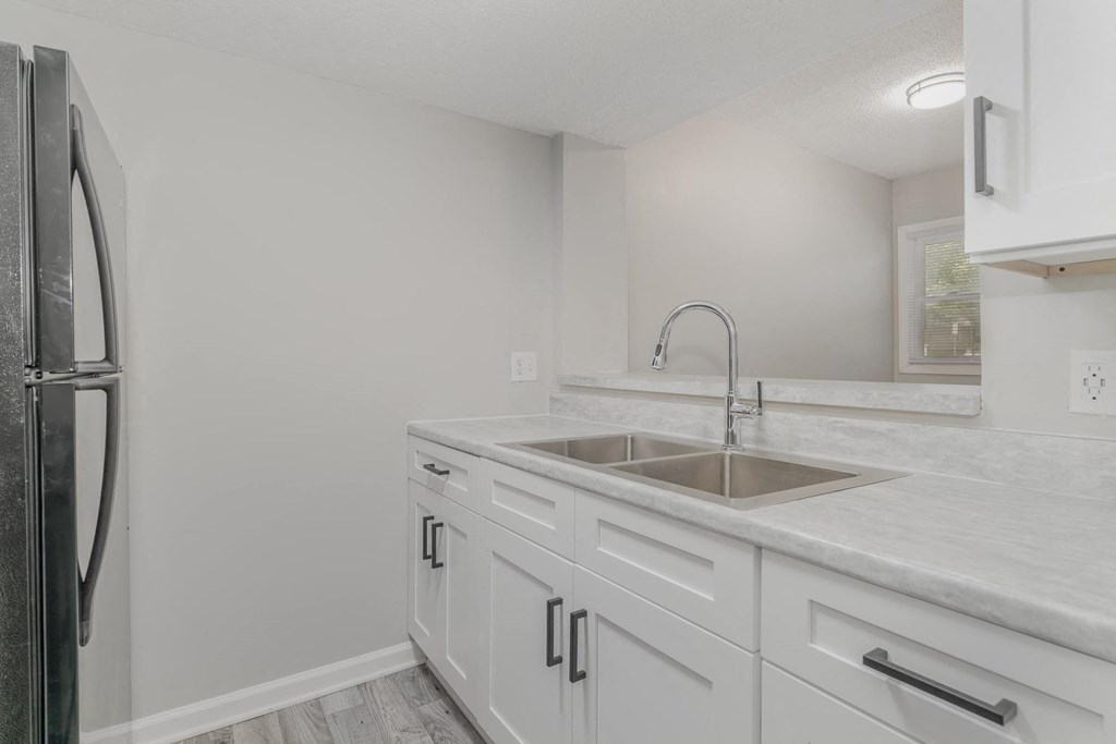 a kitchen with white cabinets and a stainless steel refrigerator
