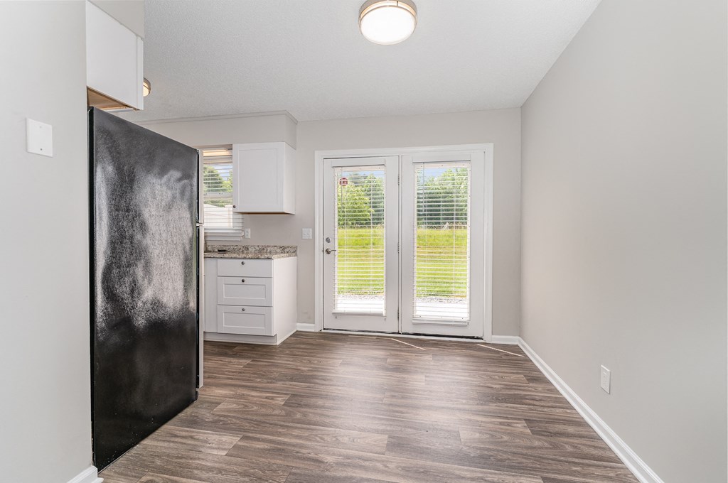 a kitchen and living room with a door leading to a yard
