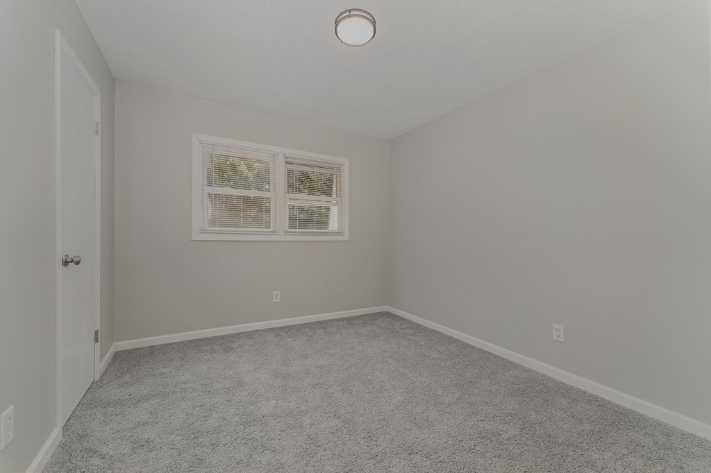 a bedroom with grey walls and carpet