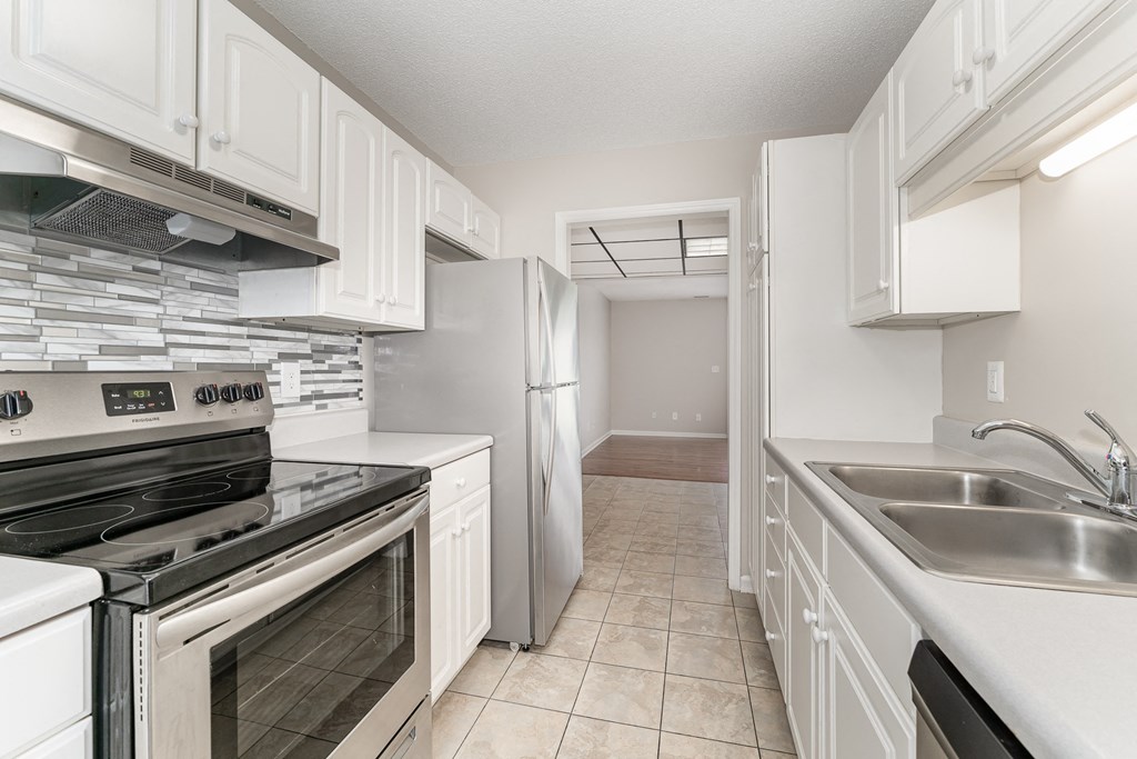 a kitchen with white cabinets and stainless steel appliances