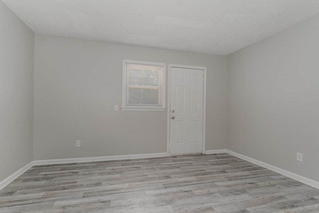 a bedroom with grey walls and a white door