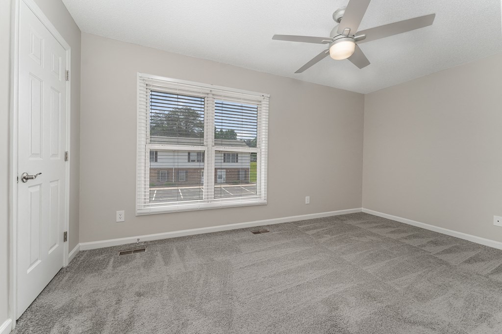 a bedroom with a ceiling fan and a window