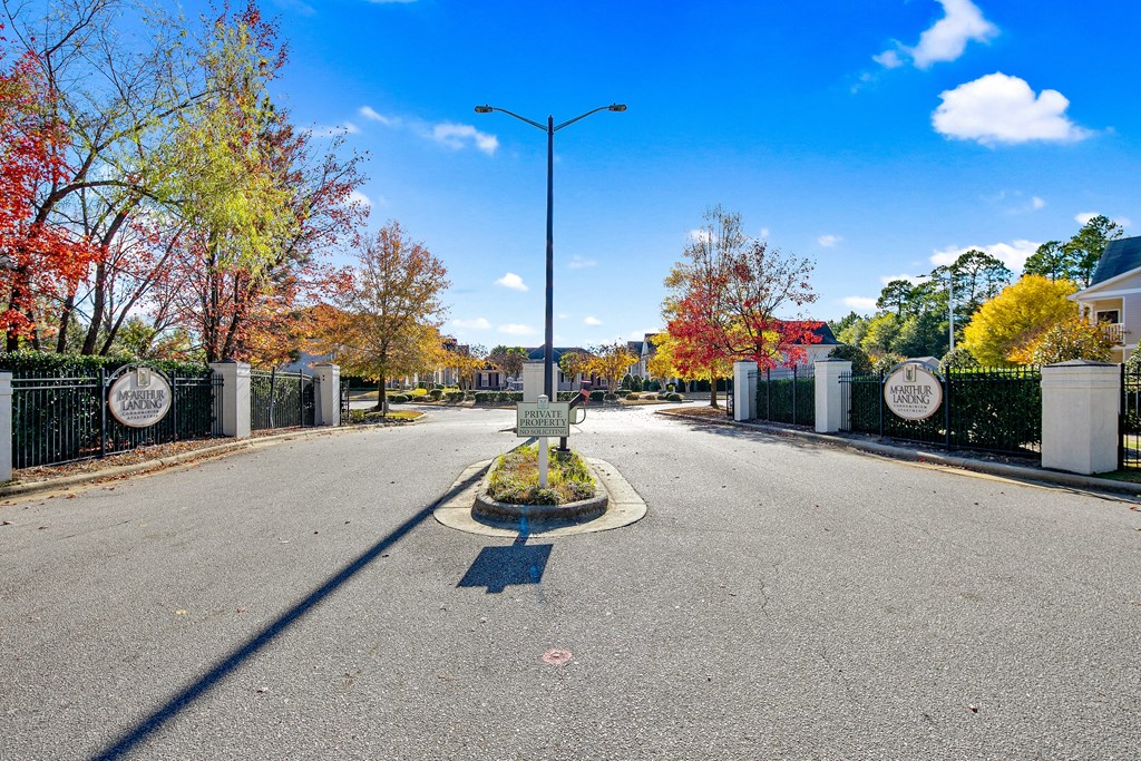 an empty street with a gate and a lamp post in the middle