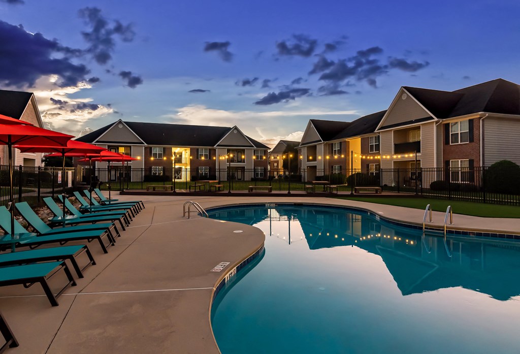 the resort style pool with lounge chairs at dusk