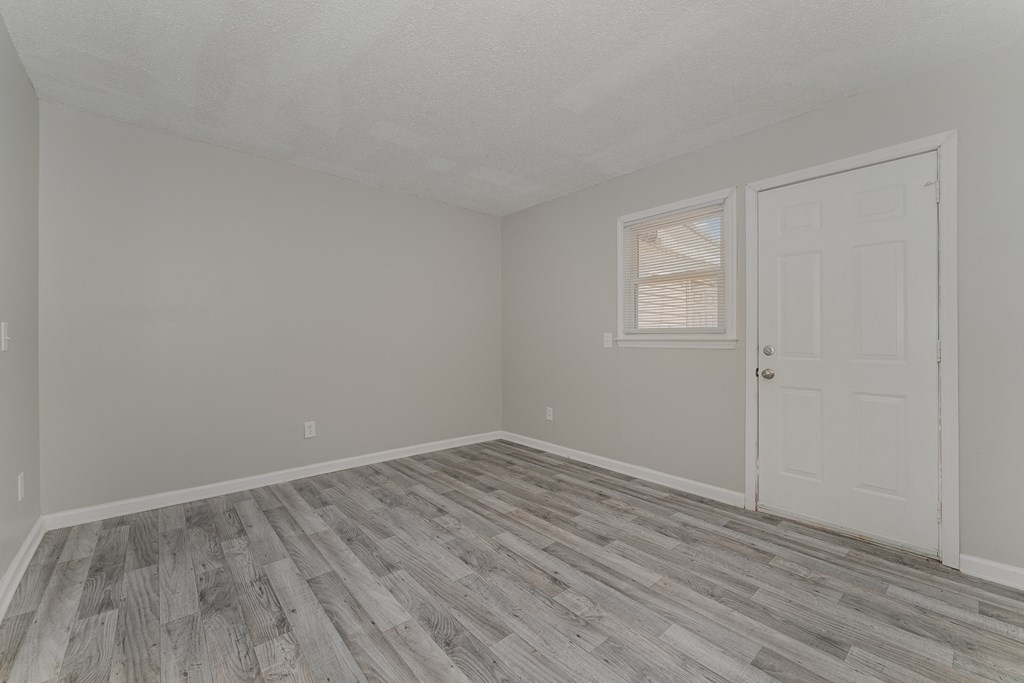 a bedroom with hardwood floors and grey walls