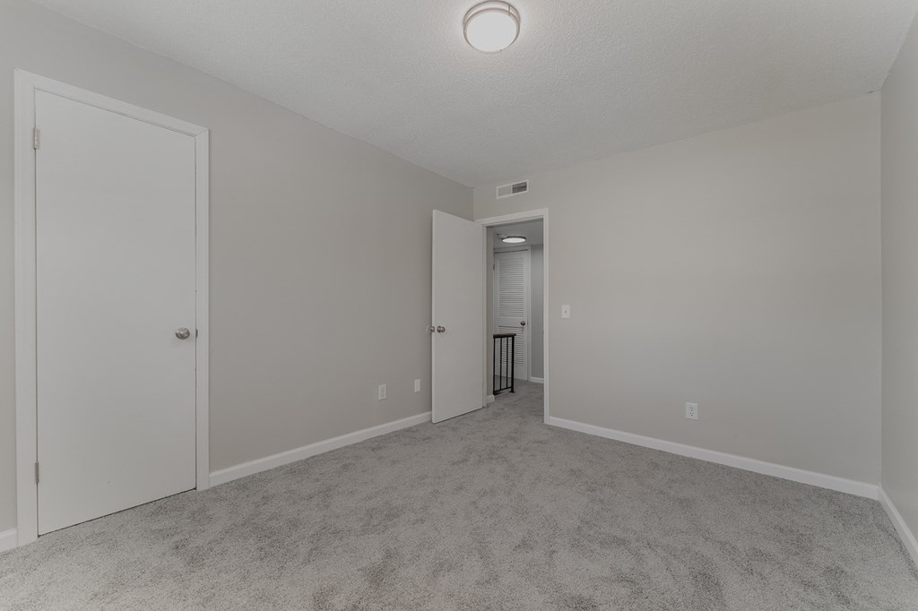 a bedroom with gray walls and carpet