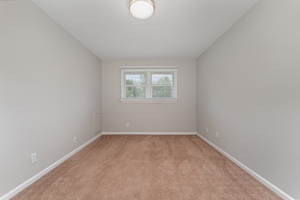 a bedroom with gray walls and a carpeted floor