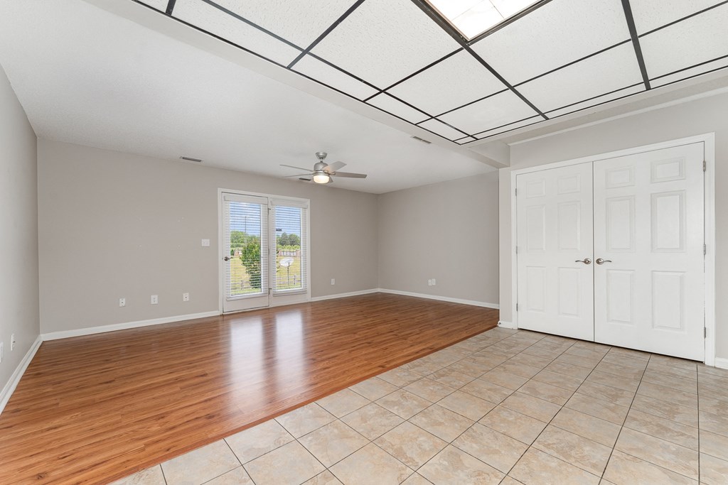a living room with a tile floor and a ceiling with a skylight