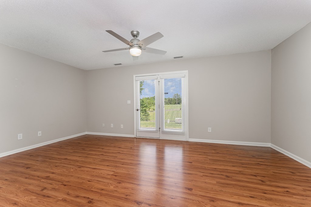 a bedroom with hardwood floors and a ceiling fan