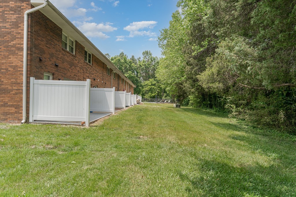 a long brick building with a grassy yard in front of it