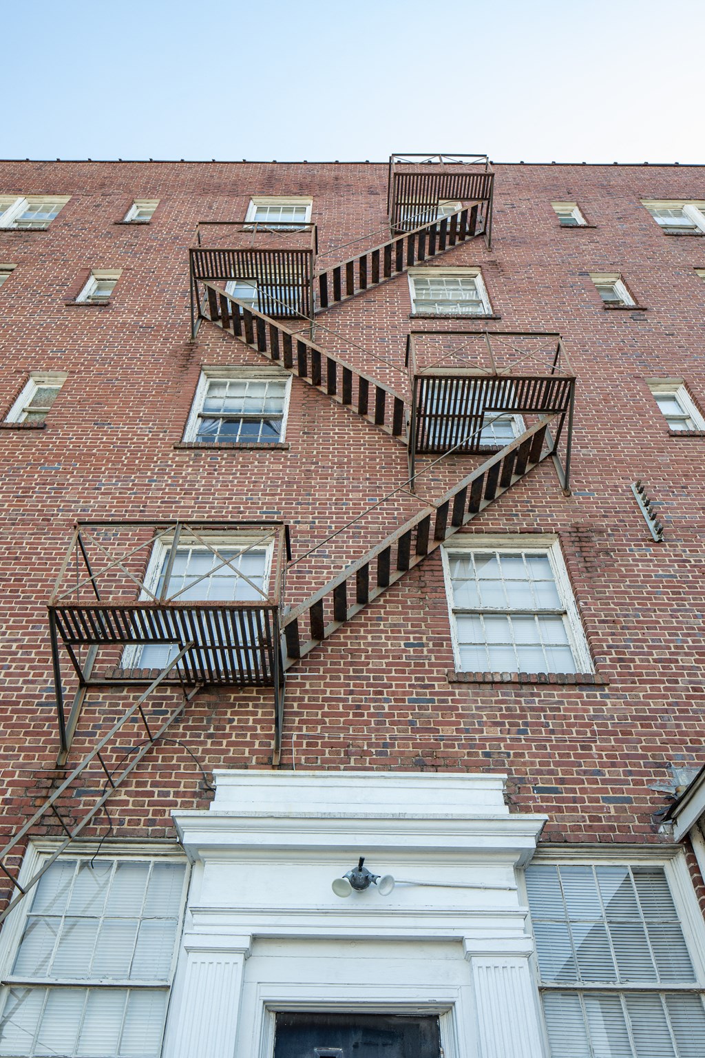 the outside of a brick building with fire escapes