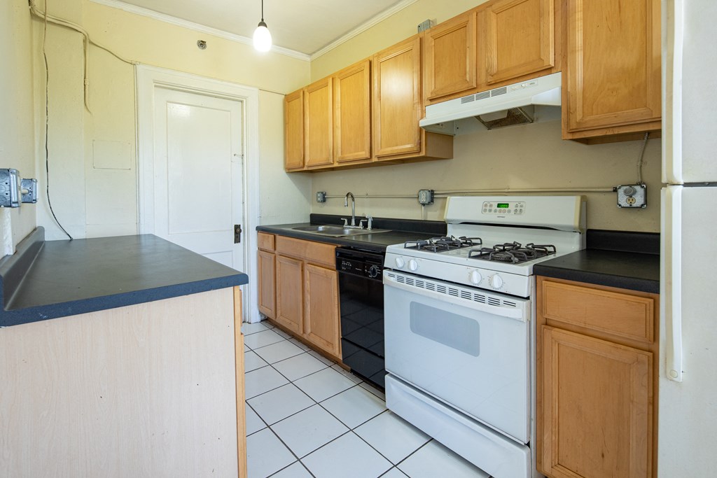 a kitchen with white appliances and wooden cabinets