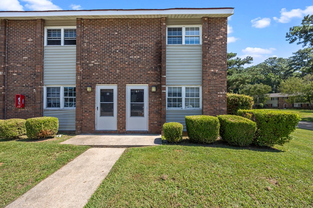 A brick building with a white door and windows.