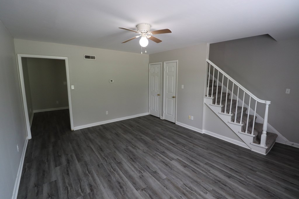 A room with a staircase and a ceiling fan.