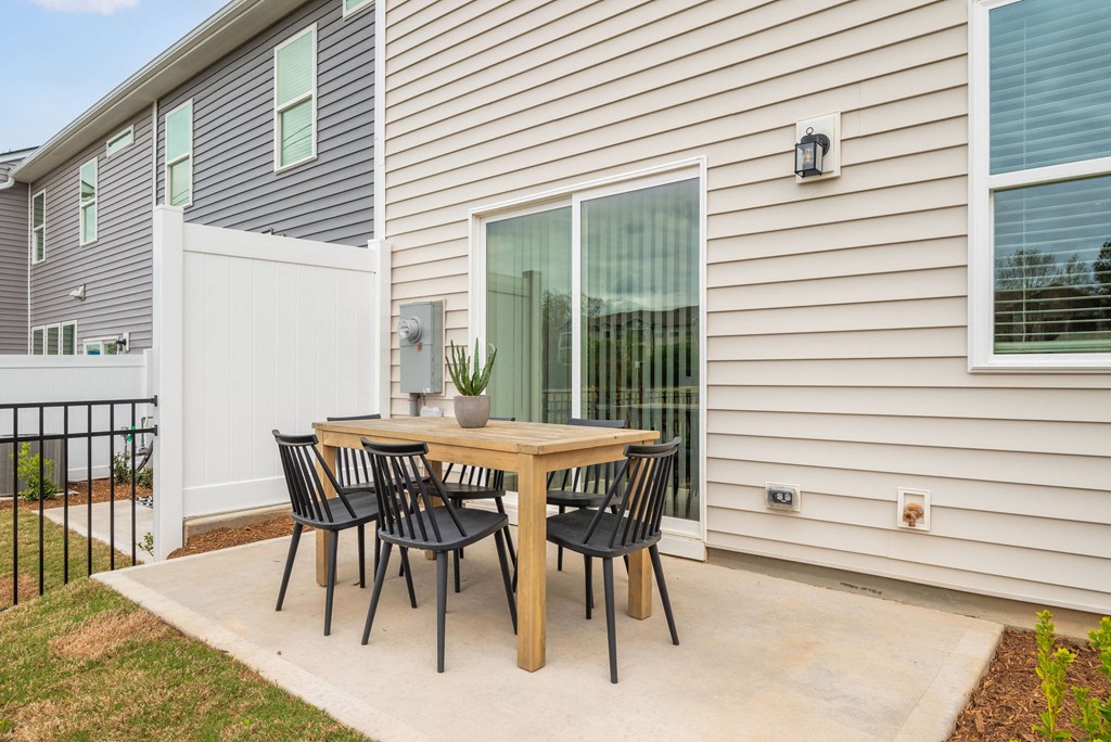 a patio with a table and chairs outside of a house