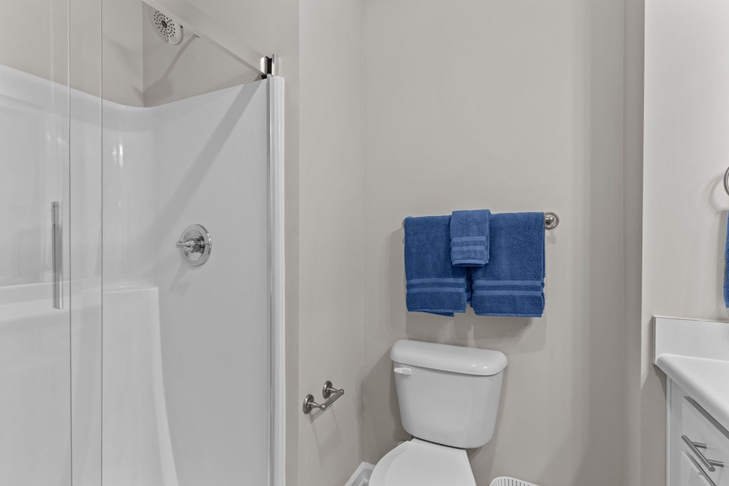 A white toilet with a blue towel on the wall.