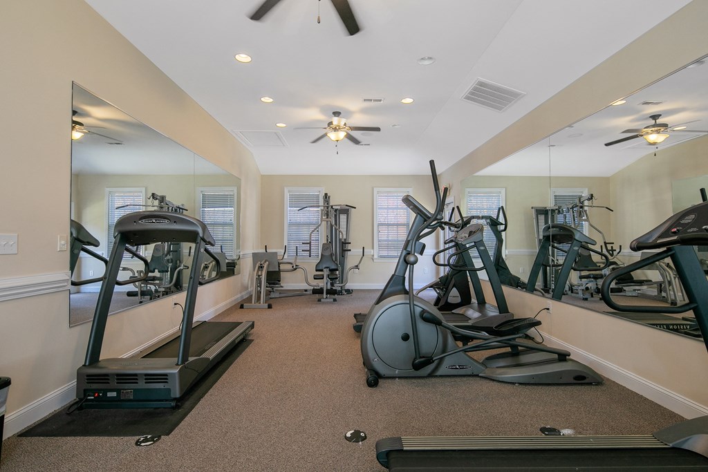 the gym with treadmills and ellipticals at the enclave at woodbridge apartments