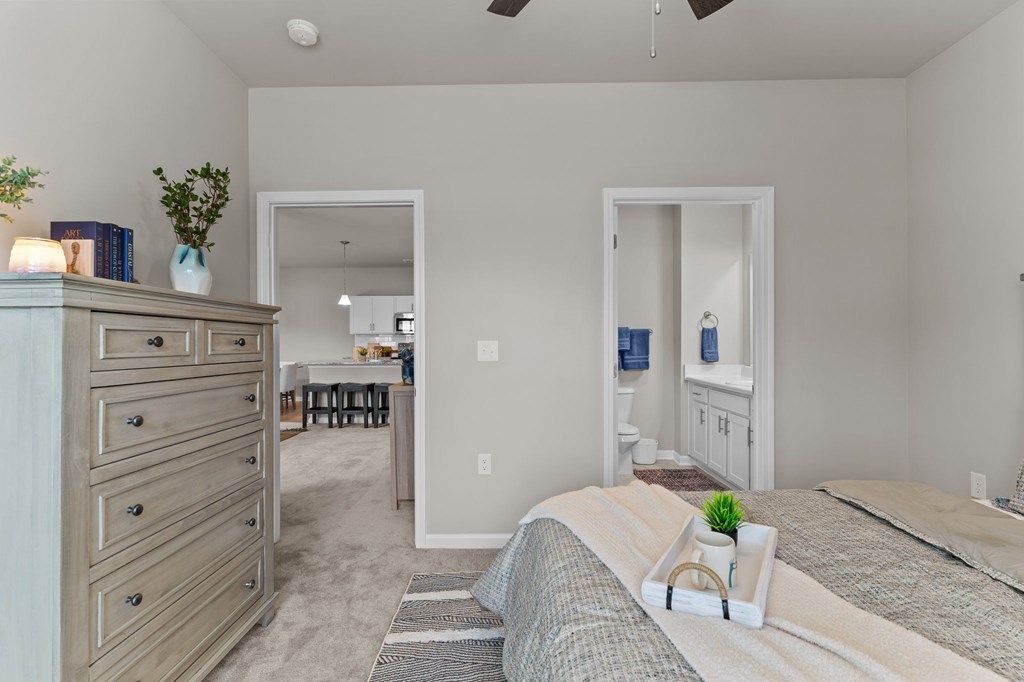 A bedroom with a bed, dresser, and mirror.