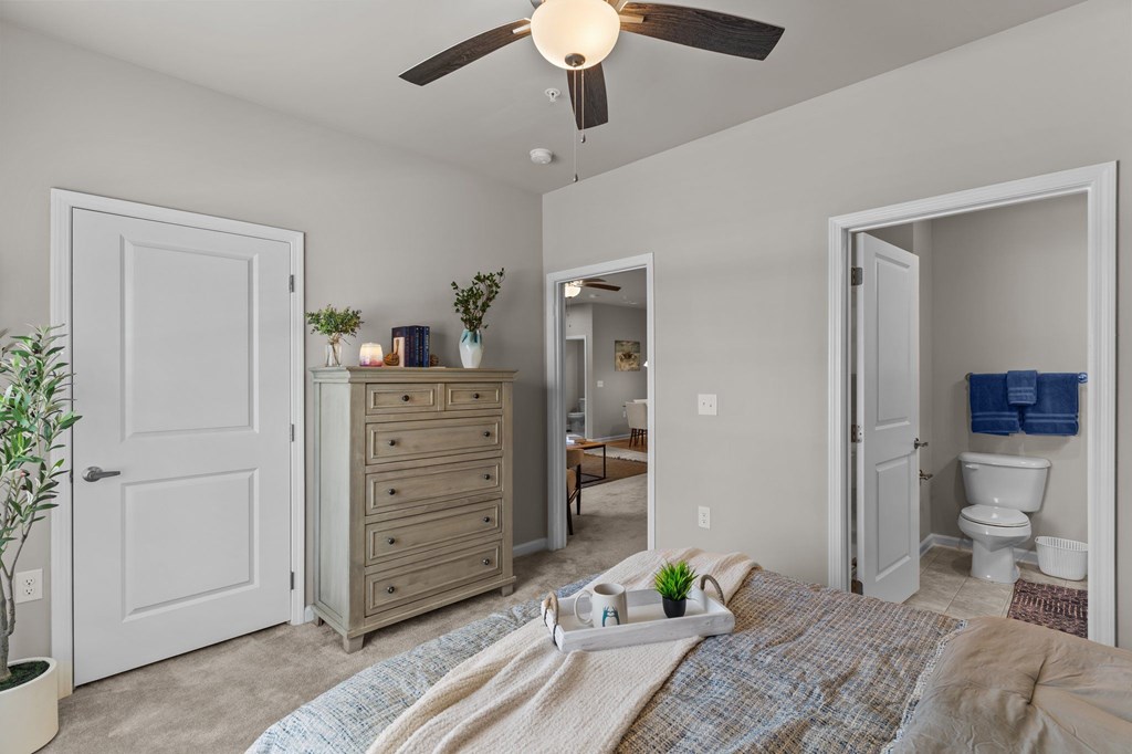 A bedroom with a bed, dresser, and mirror.