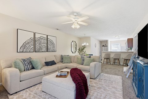 A living room with a white couch and a red throw on it.